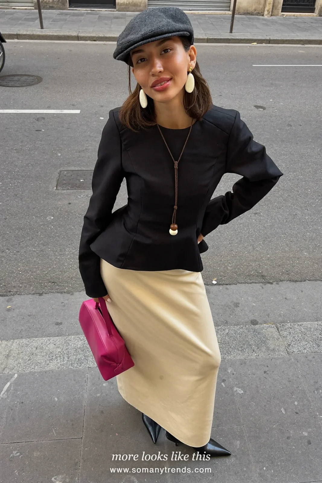 Petite woman in a black peplum top, cream column midi skirt, black pointed boots and a hot pink bag, outfit 7