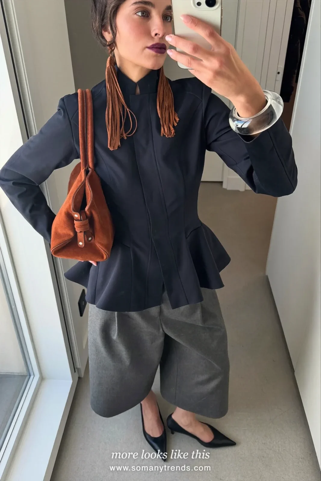 Petite woman in a navy twill peplum jacket, wide gray trousers, black pointed pumps and a rust suede bag, outfit 9