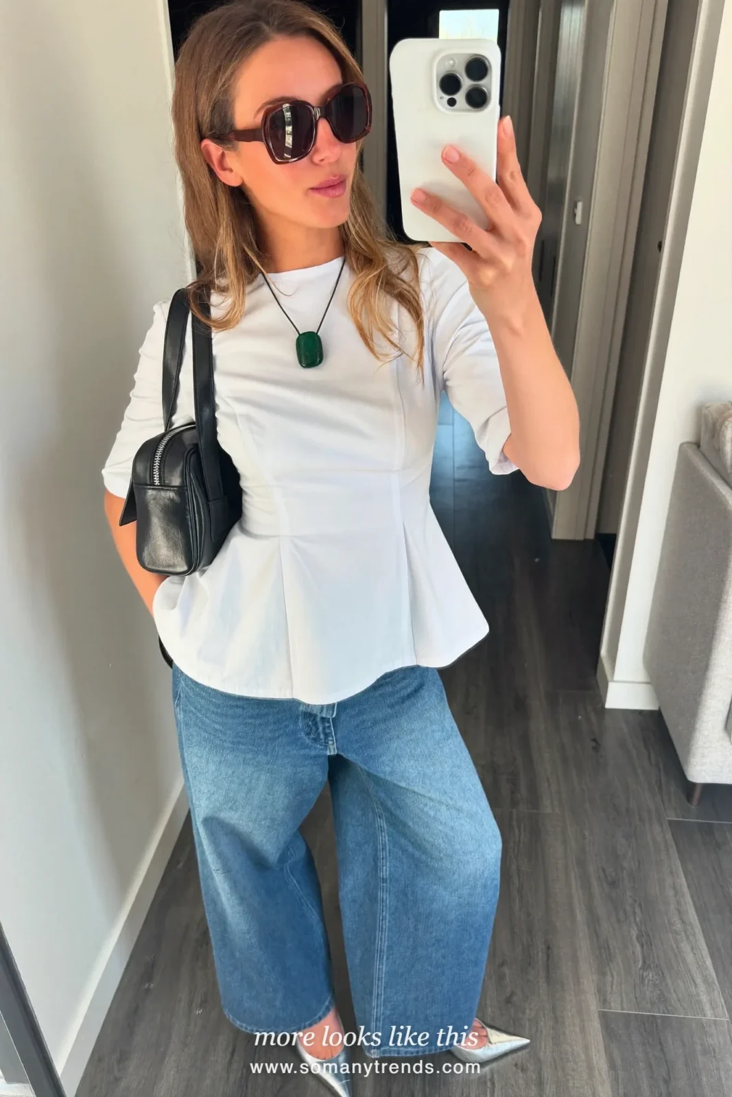 Petite woman in a white poplin peplum top, icy blue wide-leg jeans, silver pointed pumps and a black bag, outfit 12