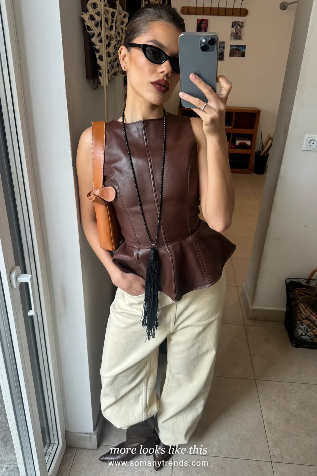 Petite woman in a chocolate leather peplum top, wide cream jeans, chocolate pointed boots and a tan bag, outfit 24