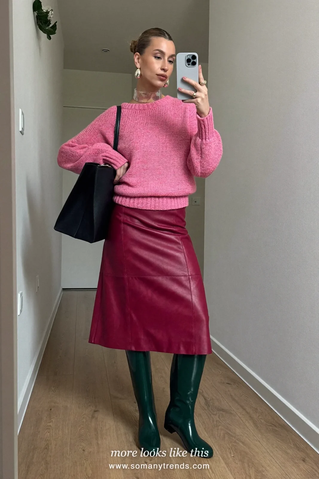 Woman in dark green glossy tall rain boots, oxblood leather midi skirt, hot pink knit and black tote, outfit 6
