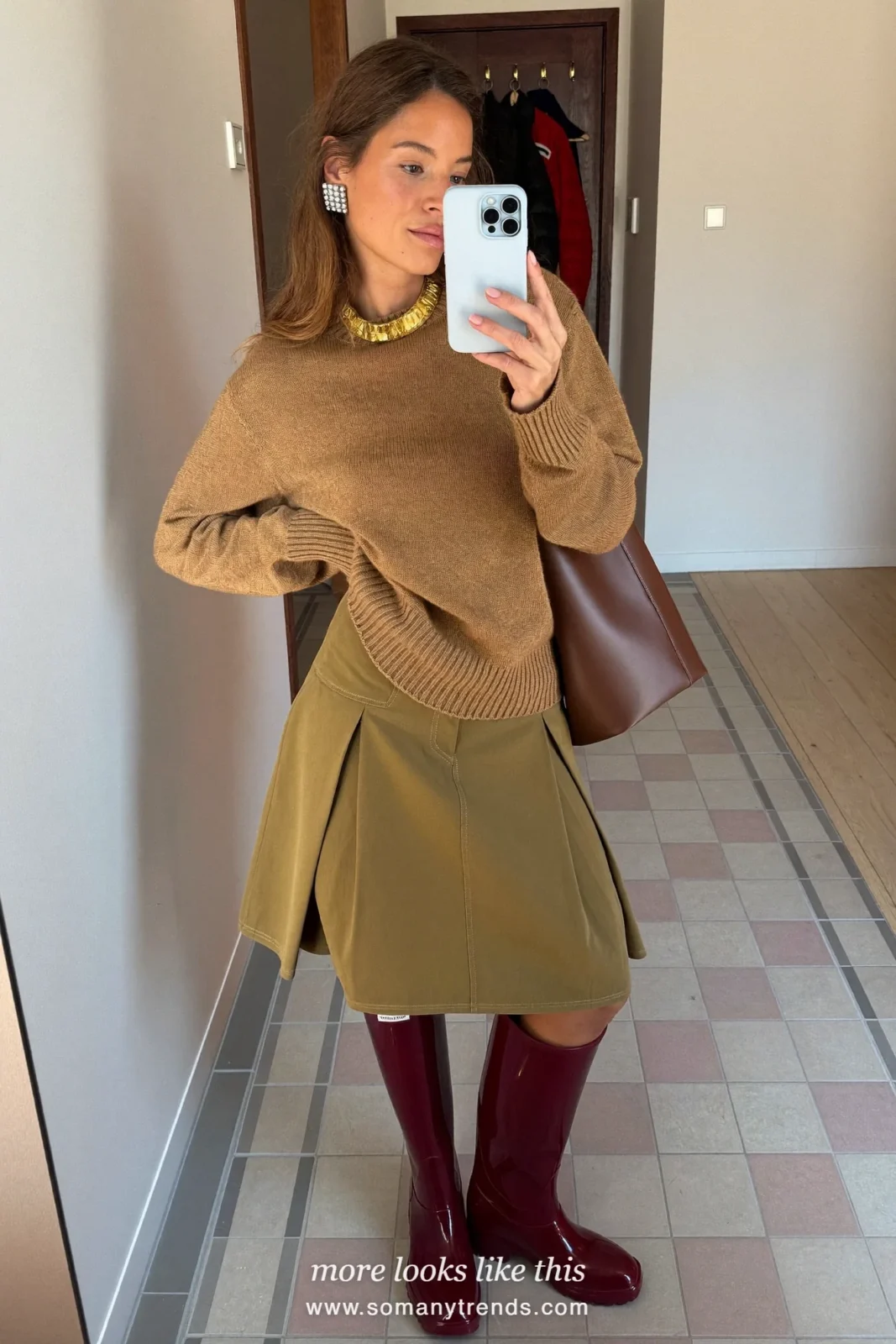 Woman in burgundy glossy tall rain boots, khaki A-line midi skirt and camel knit sweater, outfit 9