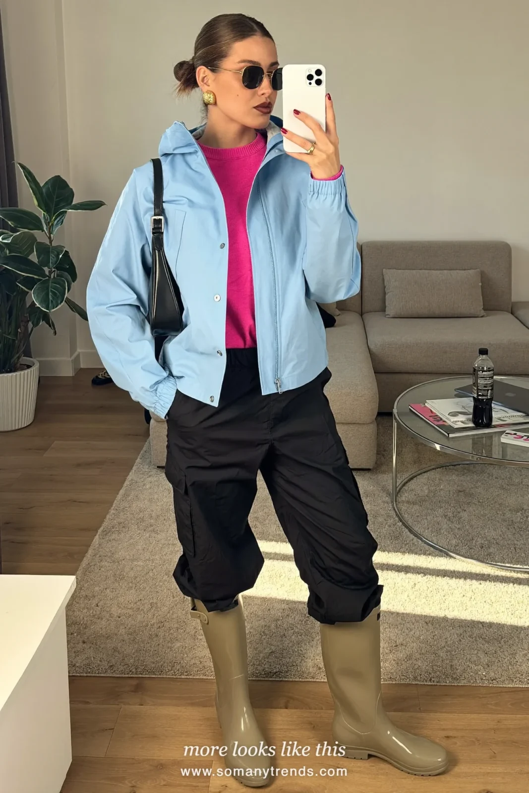 Woman in light metallic bronze short rain boots, black nylon cargo pants, hot pink sweater and pale blue zip rain jacket, outfit 12