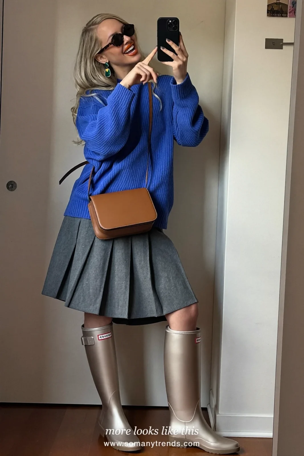 Woman in light metallic bronze tall rubber rain boots, gray pleated midi skirt and cobalt blue sweater, outfit 15