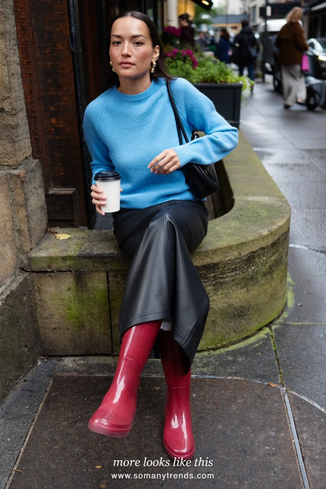 Woman in cherry red glossy tall rain boots, black leather midi skirt and sky blue knit, outfit 19