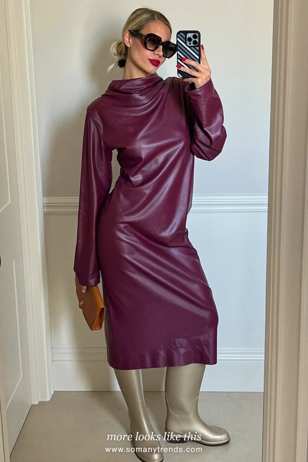 Woman in light metallic bronze tall rubber rain boots, plum midi dress with sleeves and mocha clutch at a venue entrance, outfit 24