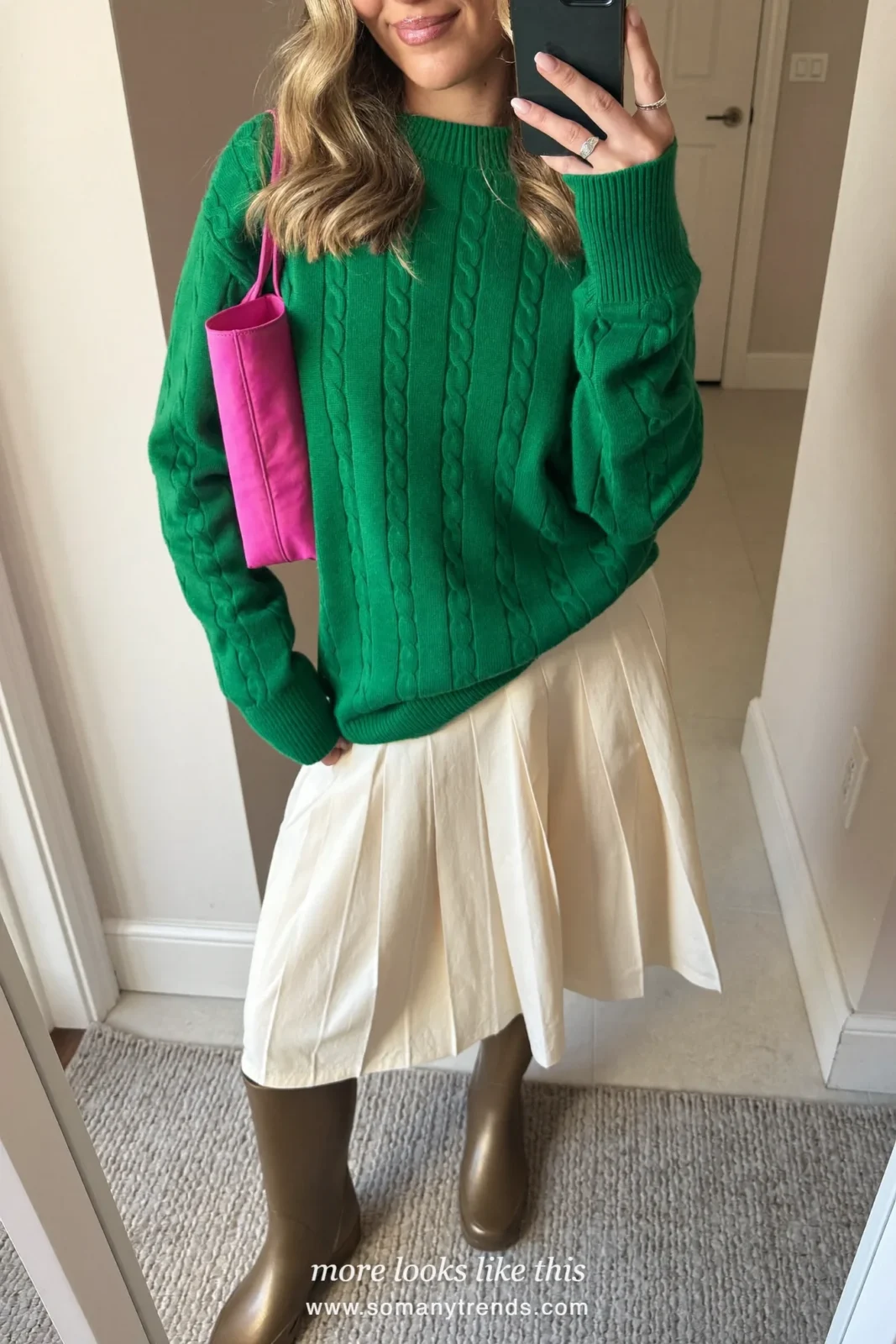Woman in light metallic bronze tall rain boots, cream pleated midi skirt, emerald green knit and hot pink tote, outfit 27