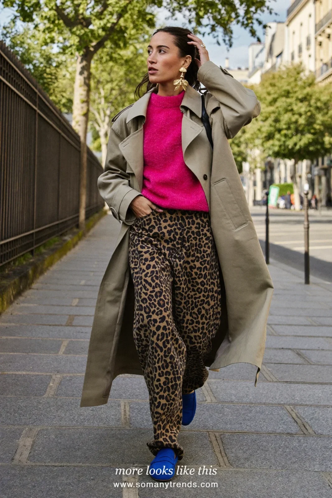 Woman in long beige trench coat worn open over fuchsia knit, leopard print wide jeans and cobalt blue loafers, outfit 11