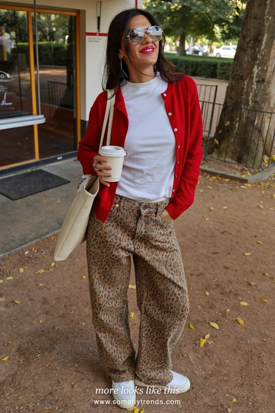 Woman in cherry red cardigan over white tee, leopard print wide jeans, white sneakers and cream tote, outfit 16