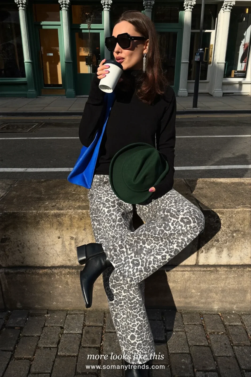 Woman in black fine-knit turtleneck, snow leopard gray and white print jeans, black ankle boots and cobalt blue shoulder bag, outfit 17