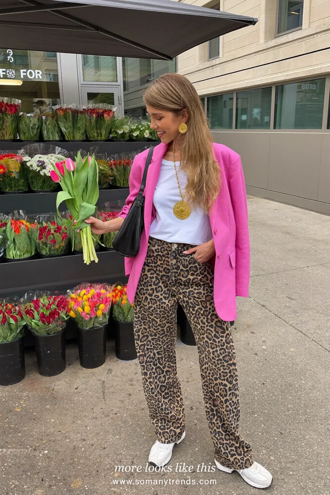 Woman in hot pink blazer, white tee, leopard print wide jeans, white sneakers and black shoulder bag, outfit 20