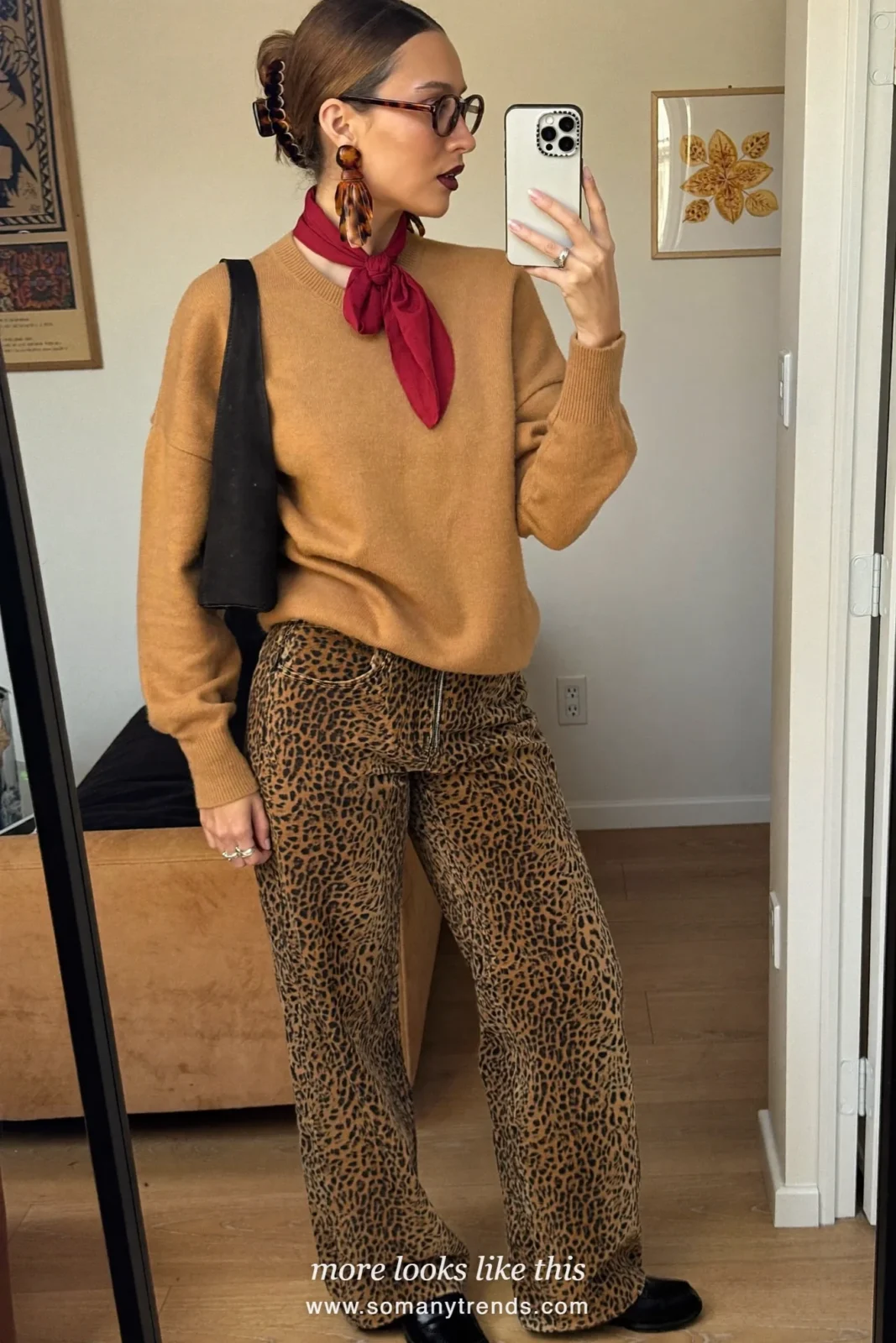 Woman in camel knit sweater, leopard print straight jeans, black loafers and black shoulder bag, outfit 21