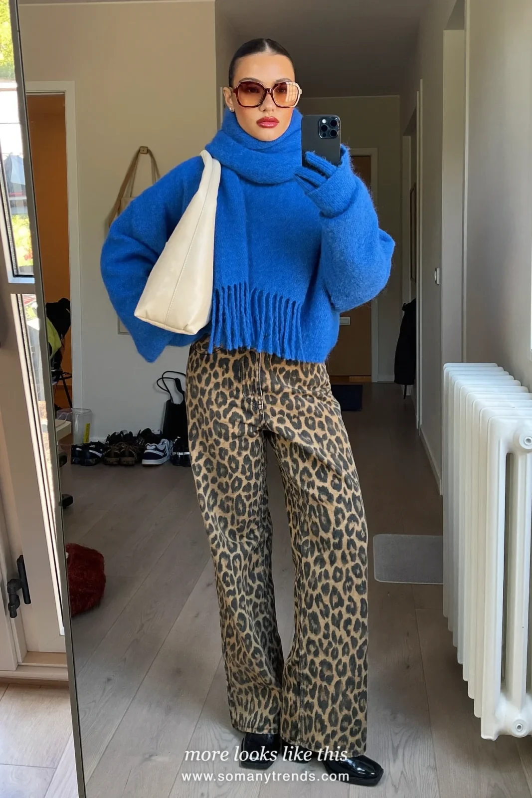 Woman in cobalt blue knit sweater with scarf and gloves, leopard print straight jeans, black ankle boots and cream tote, outfit 24