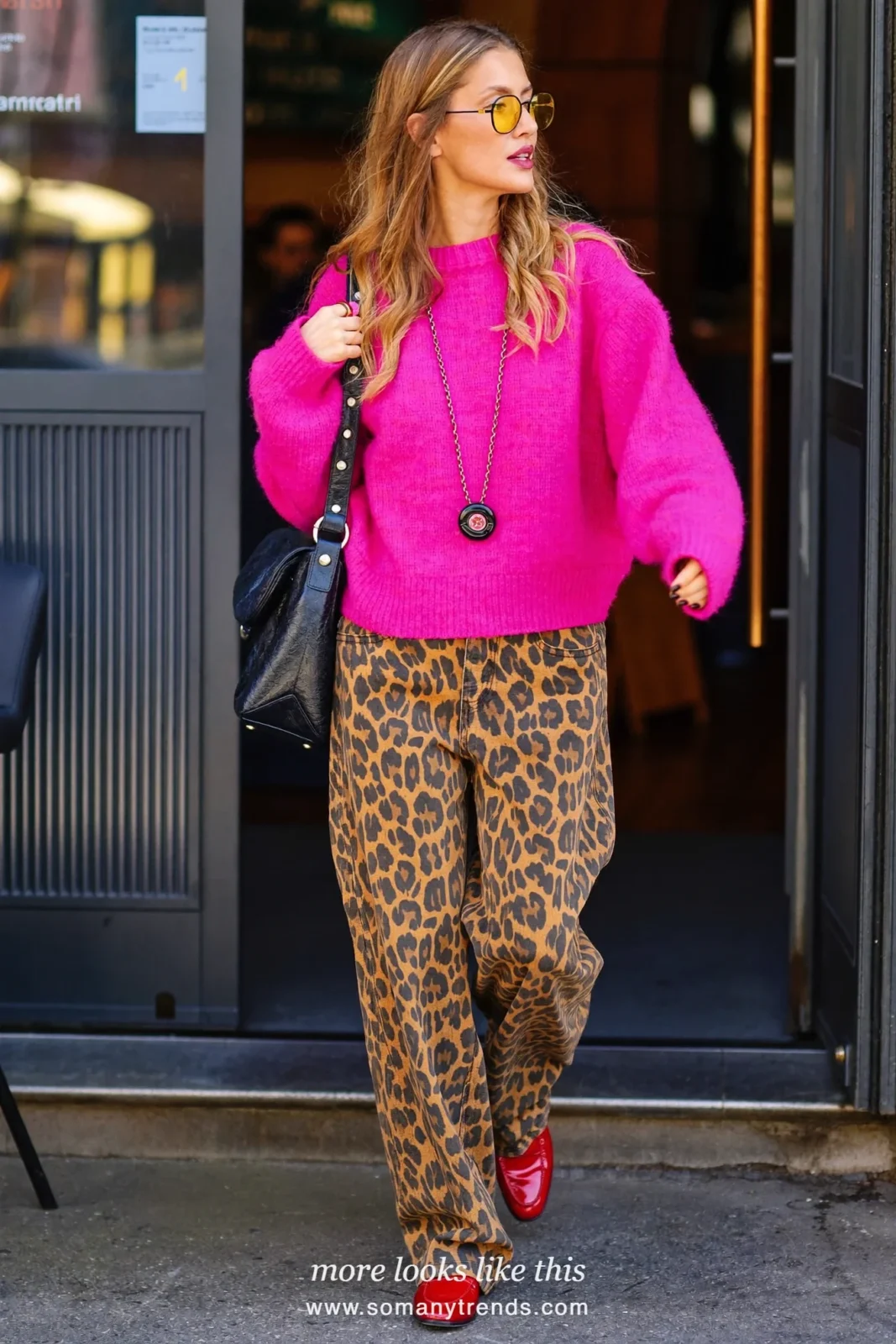 Woman in fuchsia knit sweater, leopard print wide jeans, red patent loafers and black shoulder bag, outfit 25