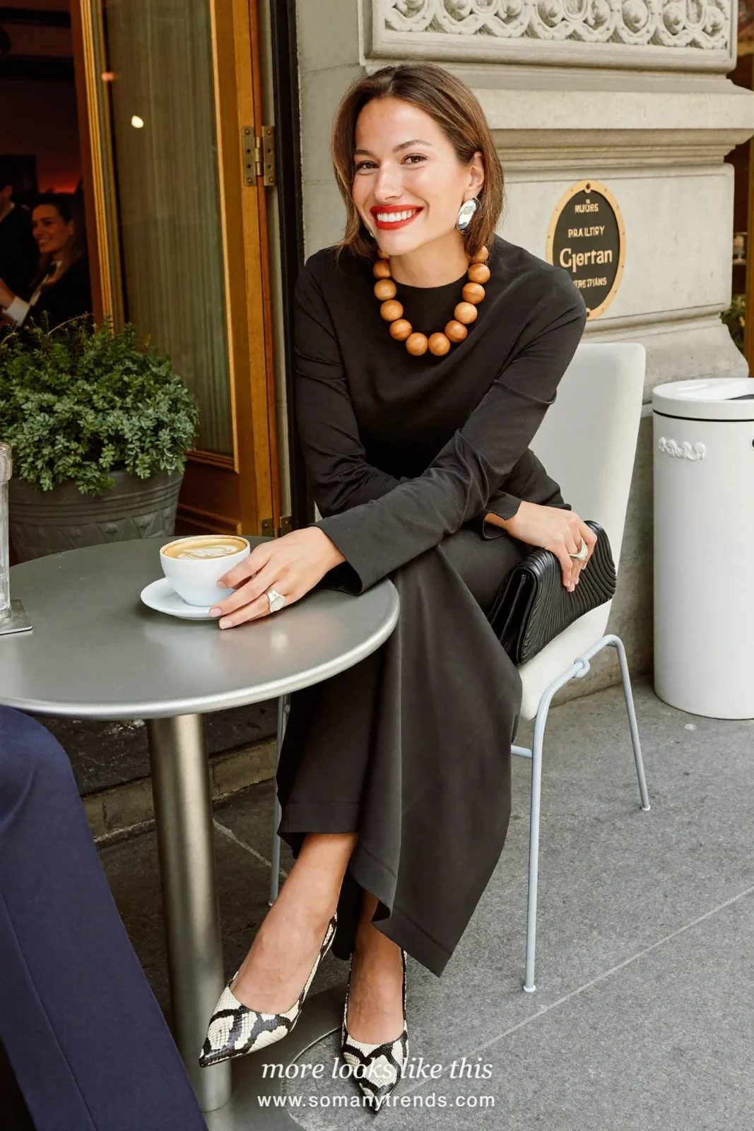 Woman in a black long sleeve crepe column dress, black and cream snake print pointed pumps and a black clutch, outfit 20
