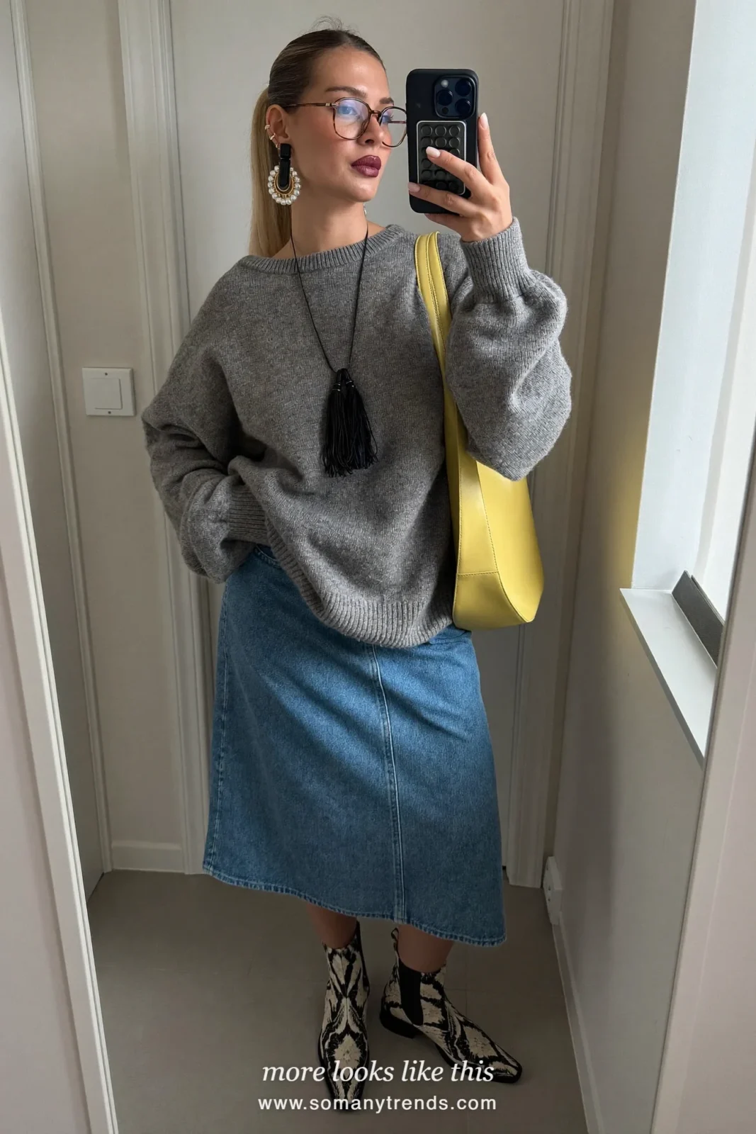 Woman in a gray knit, denim midi skirt, black and cream snake print ankle boots and a butter yellow bag, outfit 27