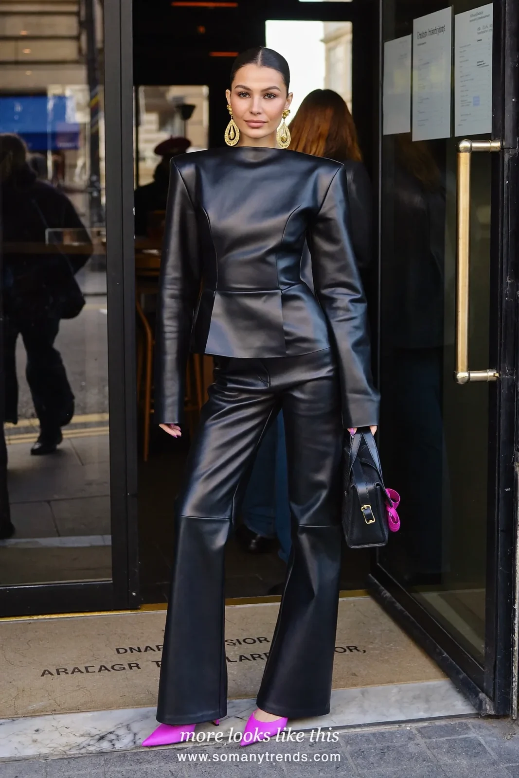 Petite woman in a black peplum top, wide black leather pants, hot pink pointed pumps and a small black bag, outfit 16