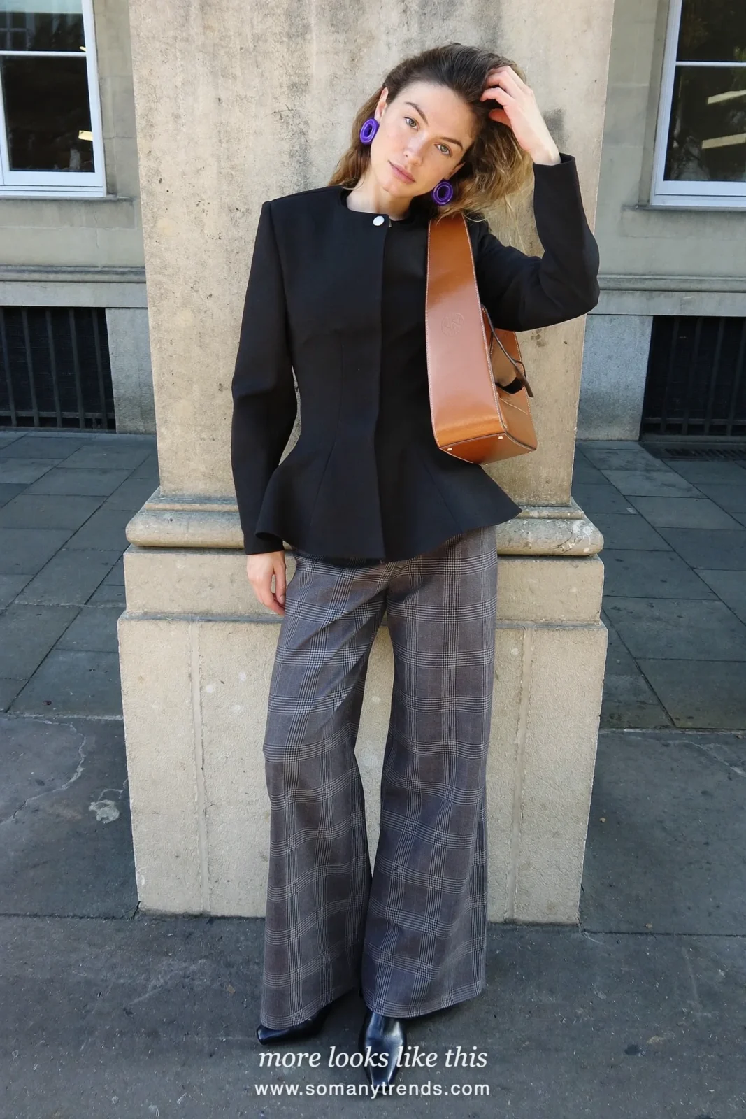 Petite woman in a black peplum jacket, wide gray plaid wool pants, black pointed boots and a cognac bag, outfit 22