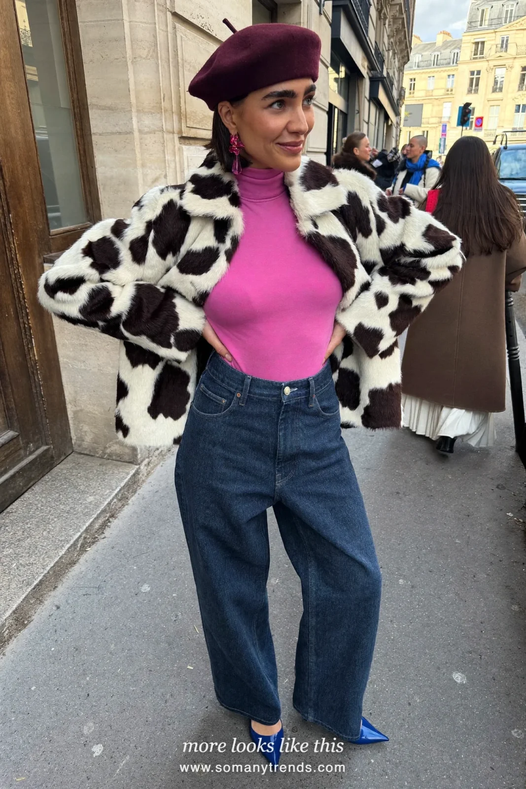 Woman in a black and white cow print jacket over a hot pink turtleneck with dark blue jeans and cobalt blue pointed pumps, outfit 5