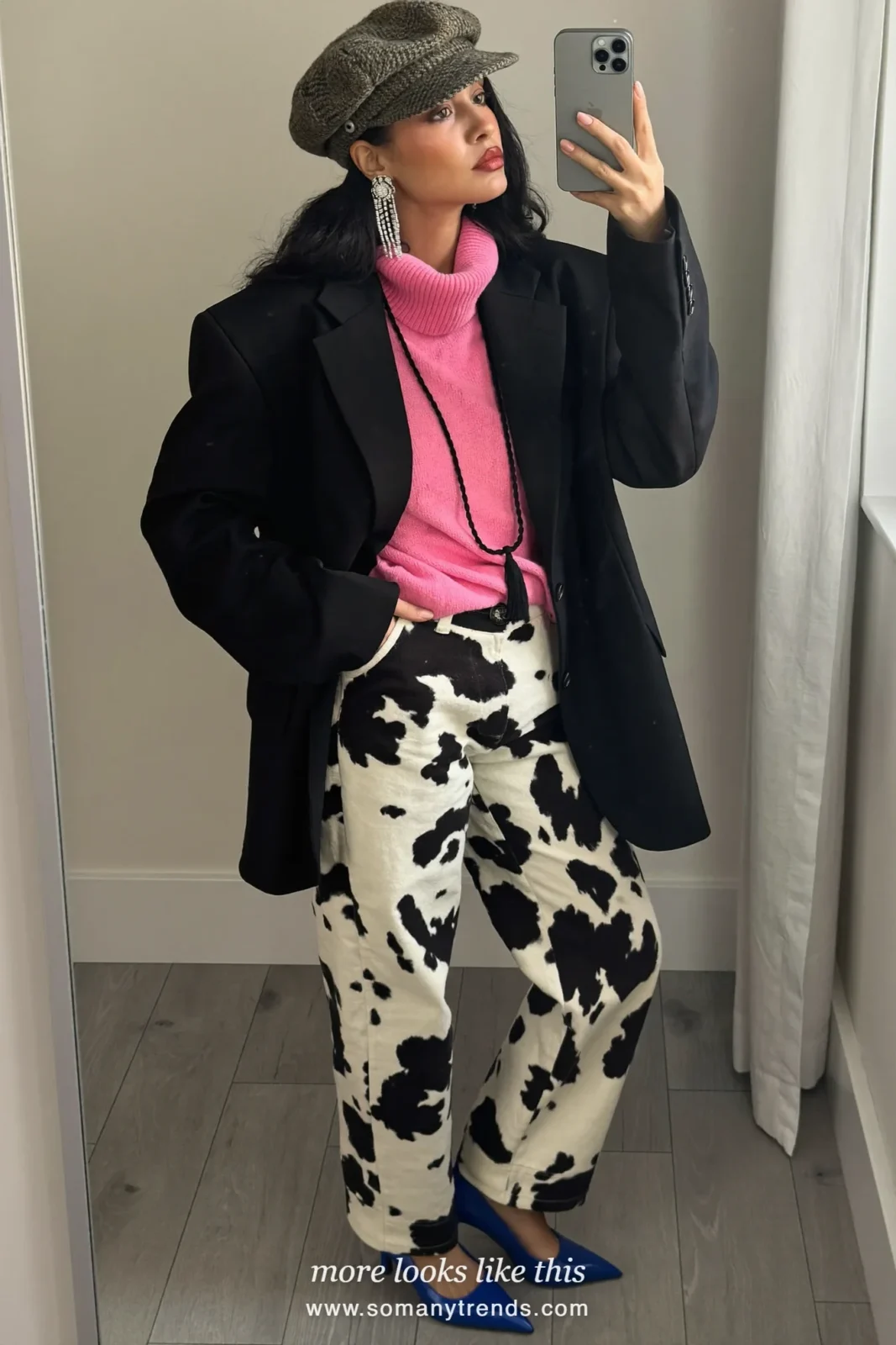 Woman in black and white cow print straight jeans with a hot pink turtleneck, black blazer and cobalt blue pointed pumps, outfit 6