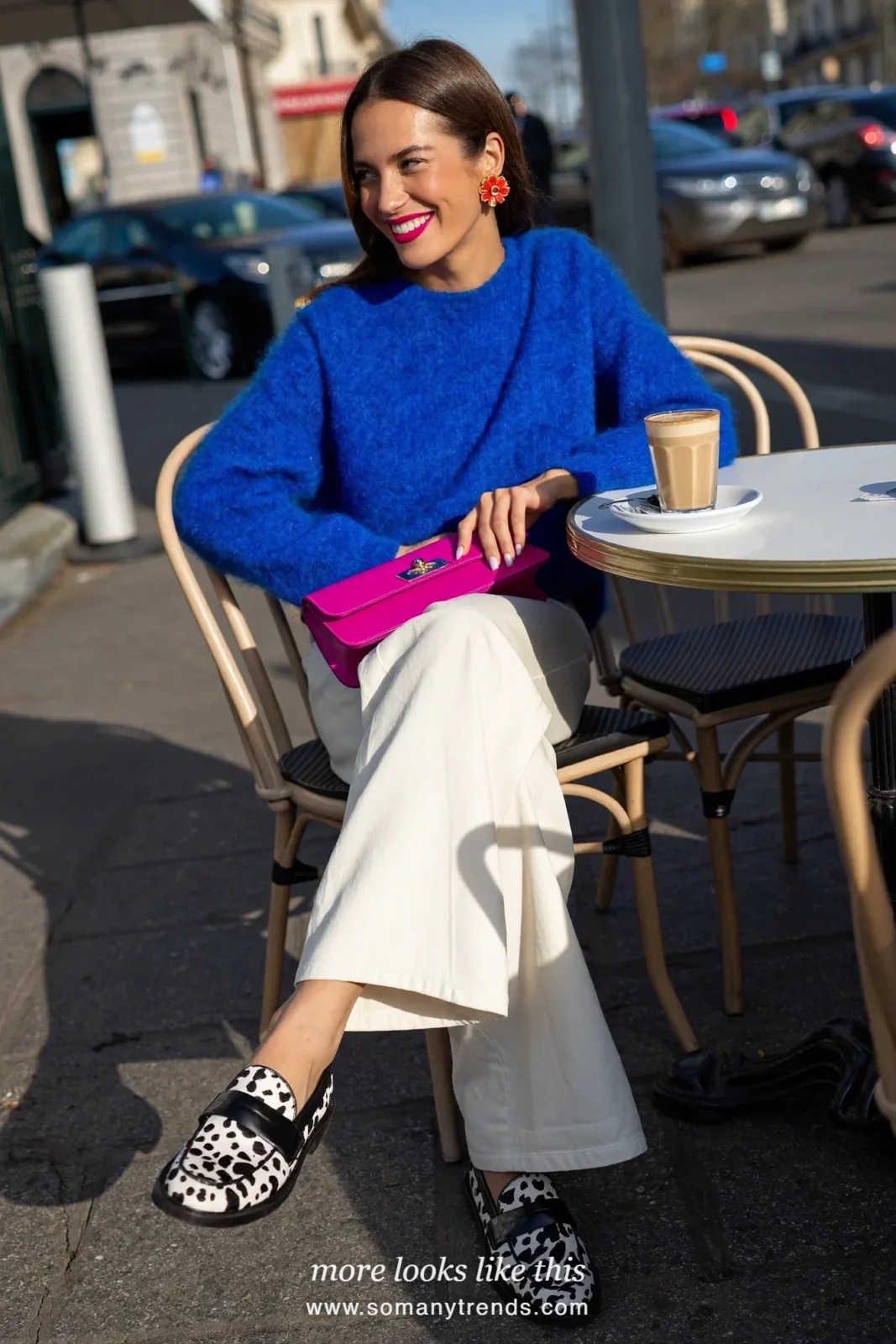 Woman in white wide pants with a cobalt blue knit, black and white cow print loafers and a hot pink bag, outfit 10