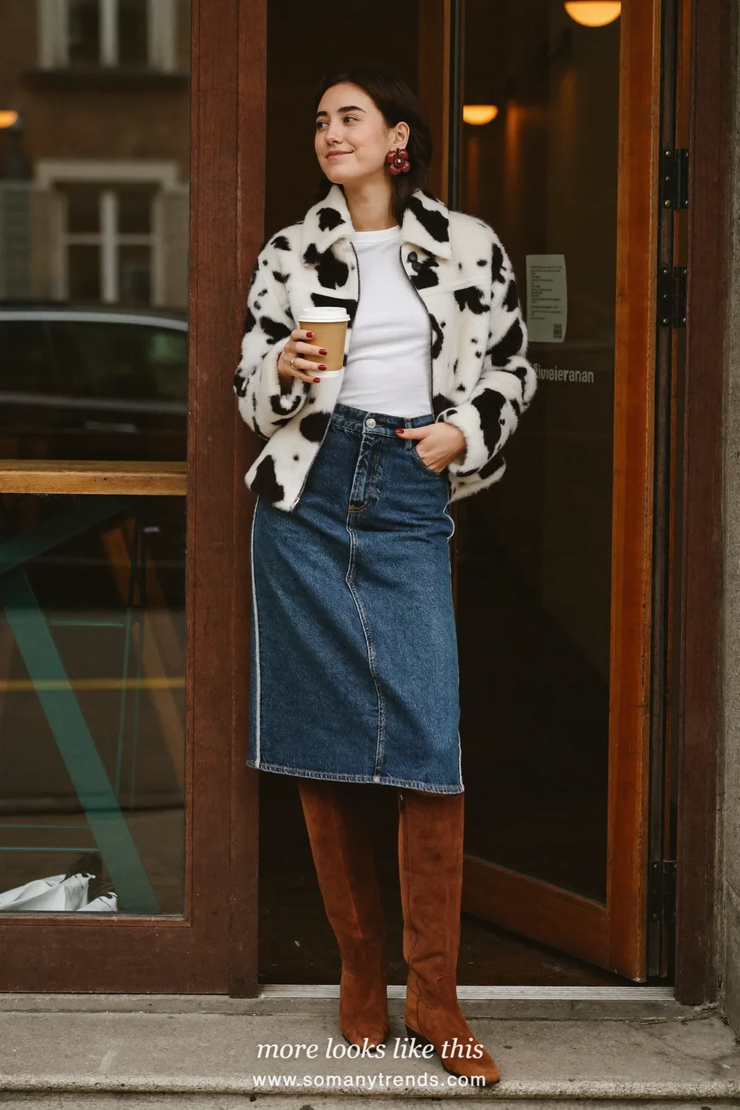 Woman in a short black and white cow print jacket with a white tee, blue denim midi skirt and chocolate brown suede knee-high boots, outfit 19