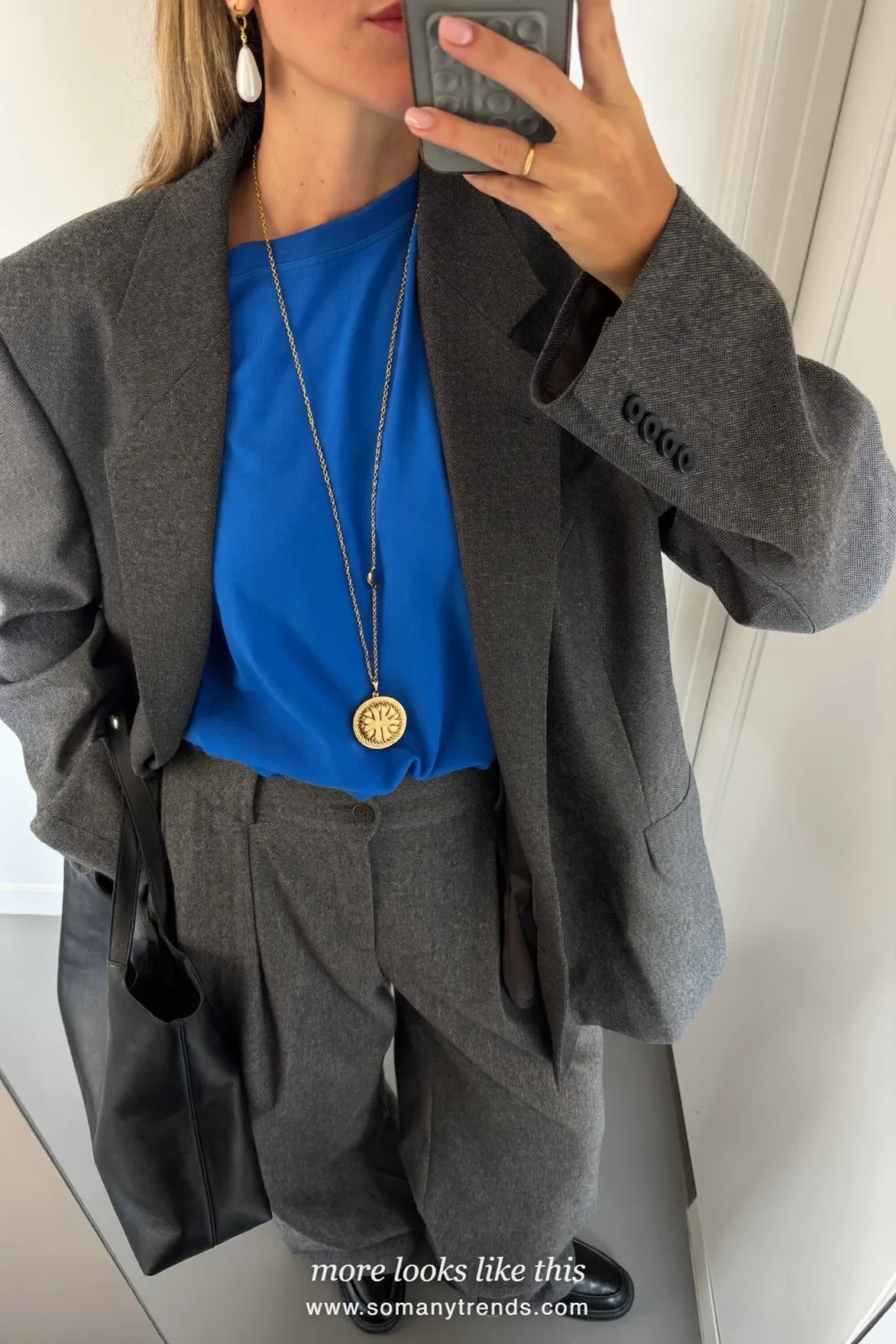Woman in a cobalt blue tee under a charcoal gray blazer and matching straight pants with black loafers, outfit 15