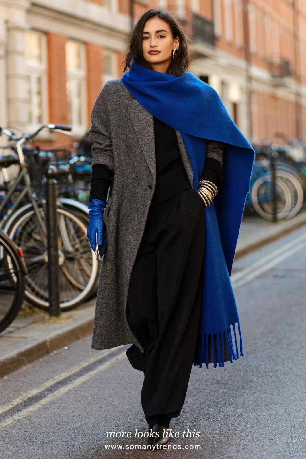Woman in a long gray wool coat with a cobalt blue scarf and gloves, black knit, black pants and black boots, outfit 16
