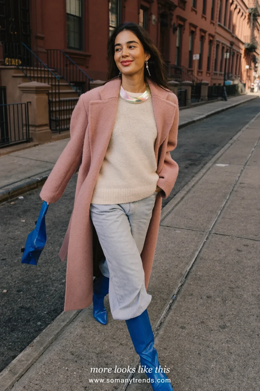 Woman in a long blush pink wool coat, cream knit, wide-leg jeans and cobalt blue leather boots, outfit 19