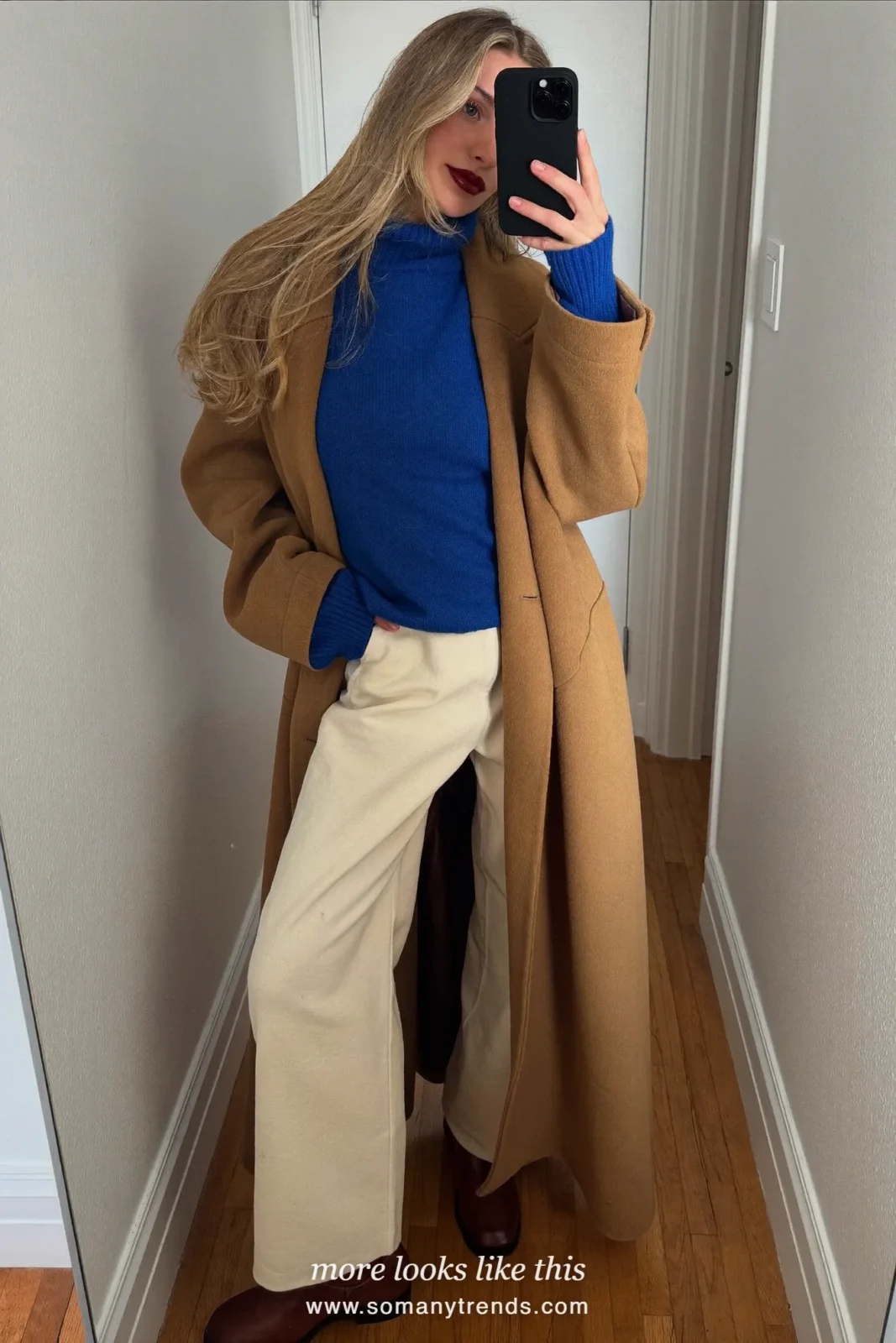 Woman in a long camel wool coat over a cobalt blue turtleneck and cream pants with brown boots, outfit 24