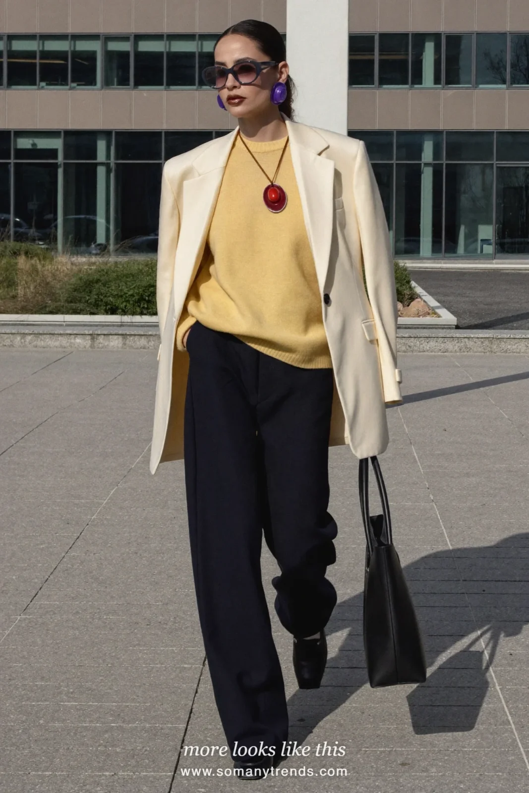 Woman in a butter yellow merino sweater, navy wide-leg pants, cream blazer and black loafers outside an office building, outfit 7