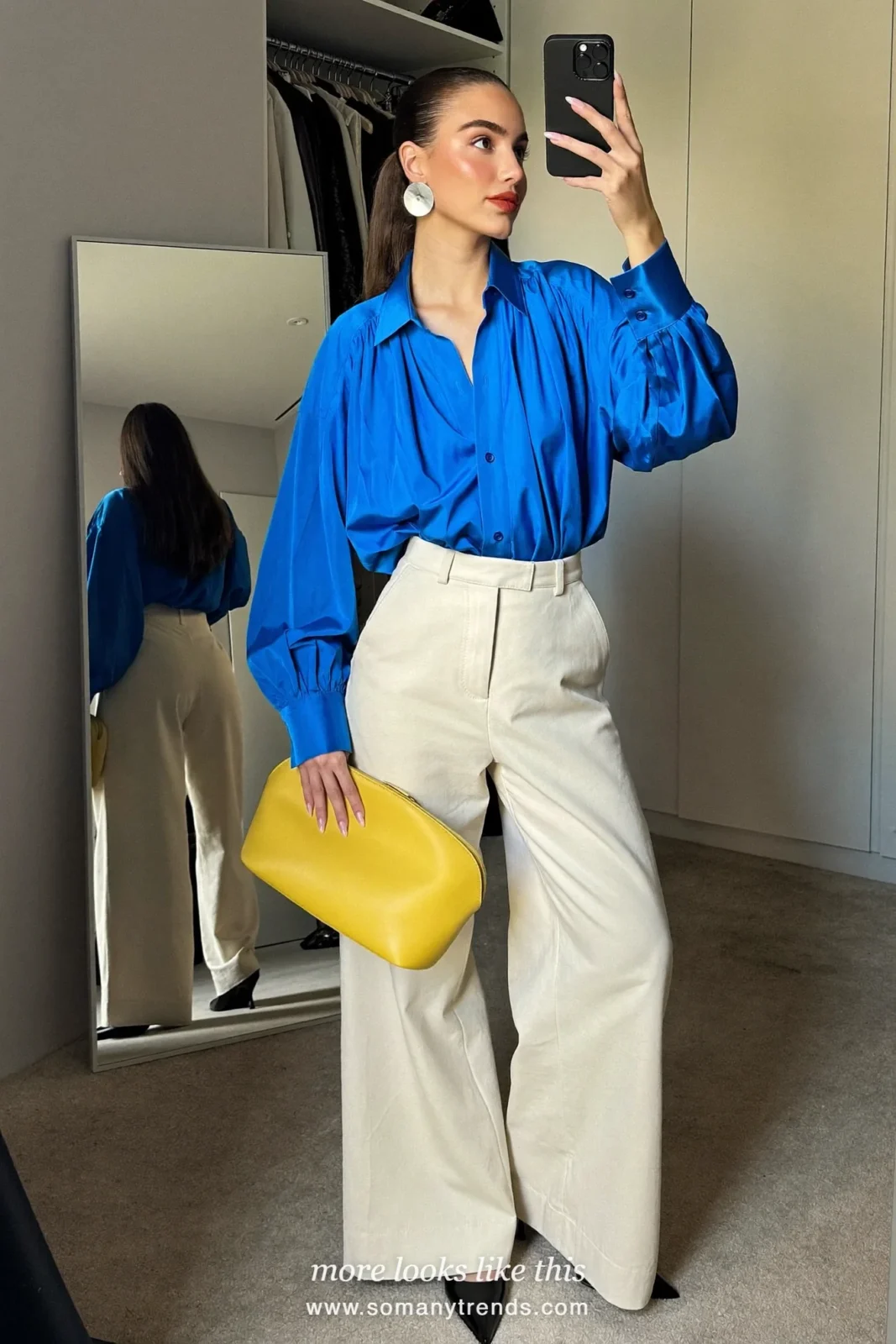 Woman in a cobalt blue silk blouse, cream wide-leg pants, pointed pumps and a lemon yellow clutch outside a restaurant, outfit 18