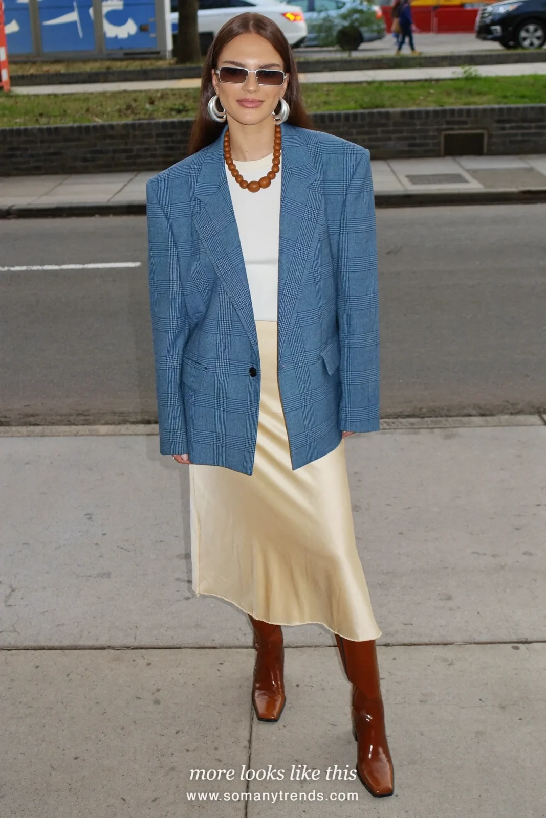 Woman in a blue plaid wool blazer, white tee, butter yellow midi slip skirt and tall brown boots on a New York street, outfit 19