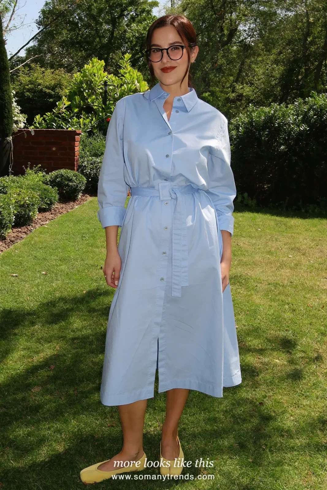 Woman in a baby blue cotton shirt dress, butter yellow flats and a straw bag in a country-house garden, outfit 26
