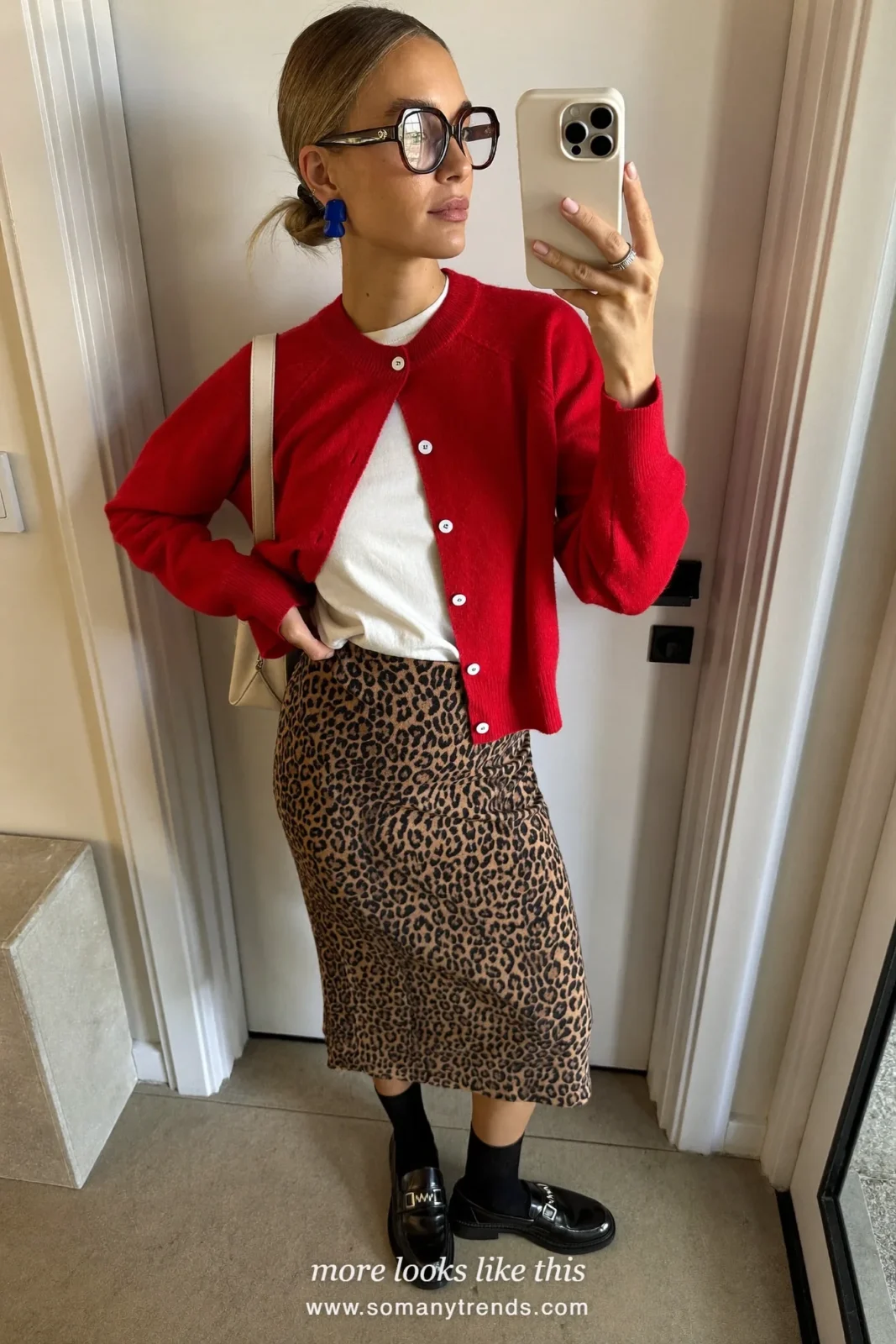 Woman in a red cardigan, white tee, leopard print midi skirt and black loafers, outfit 3