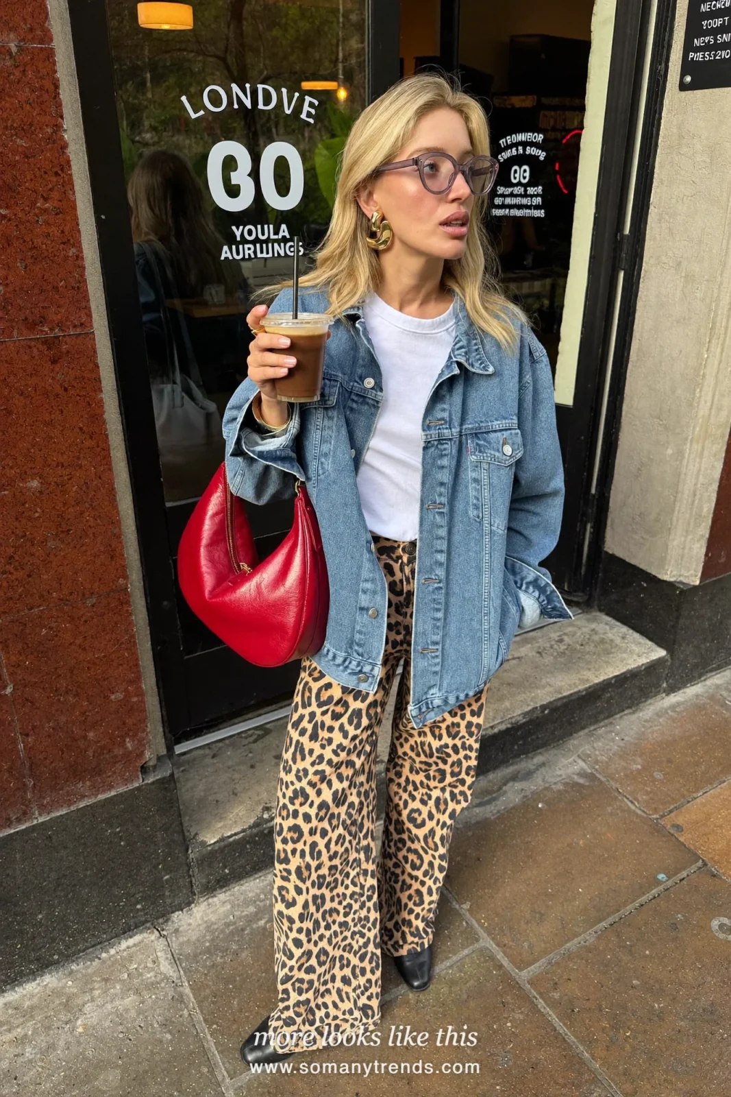 Woman in a denim jacket, white tee, leopard print pants, black ankle boots and a red bag, outfit 14