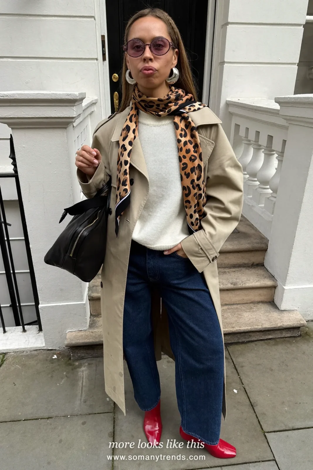 Woman in a beige trench coat, cream sweater, dark jeans, red boots and a leopard print scarf, outfit 26