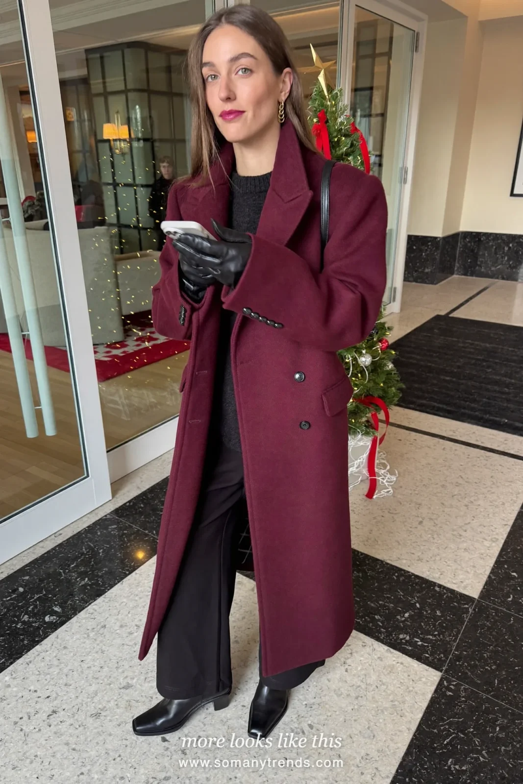 Woman in a long deep burgundy wool coat over a black sweater, black pants and black boots, outfit 8