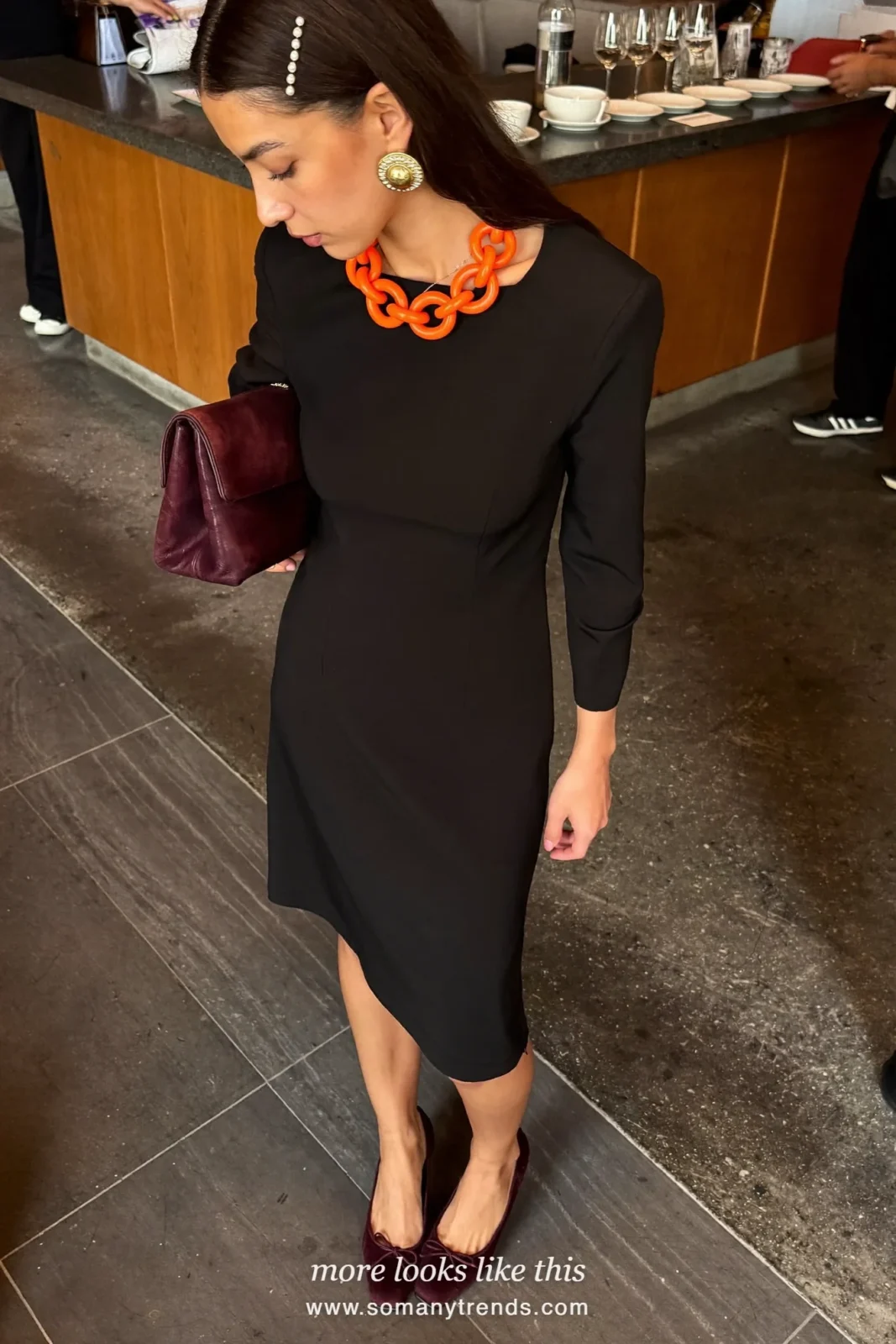 Woman in a black little dress with burgundy suede pumps and a burgundy clutch, outfit 10