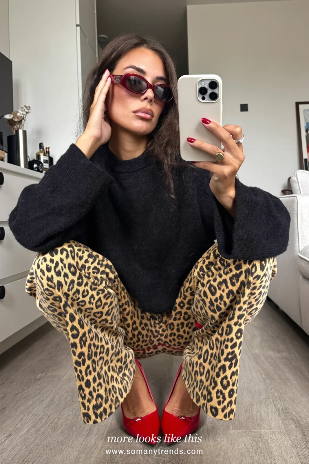 Woman in a black cashmere sweater, leopard print straight pants, cherry red pointed pumps and a black clutch, outfit 21
