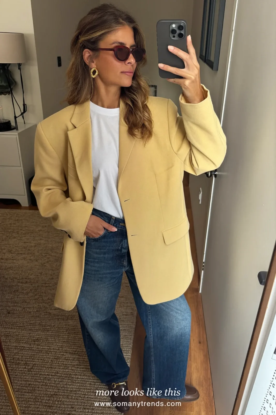 Woman in a butter yellow oversized blazer, white shirt, mid-blue wide-leg jeans and brown loafers in a New York café street, outfit 9