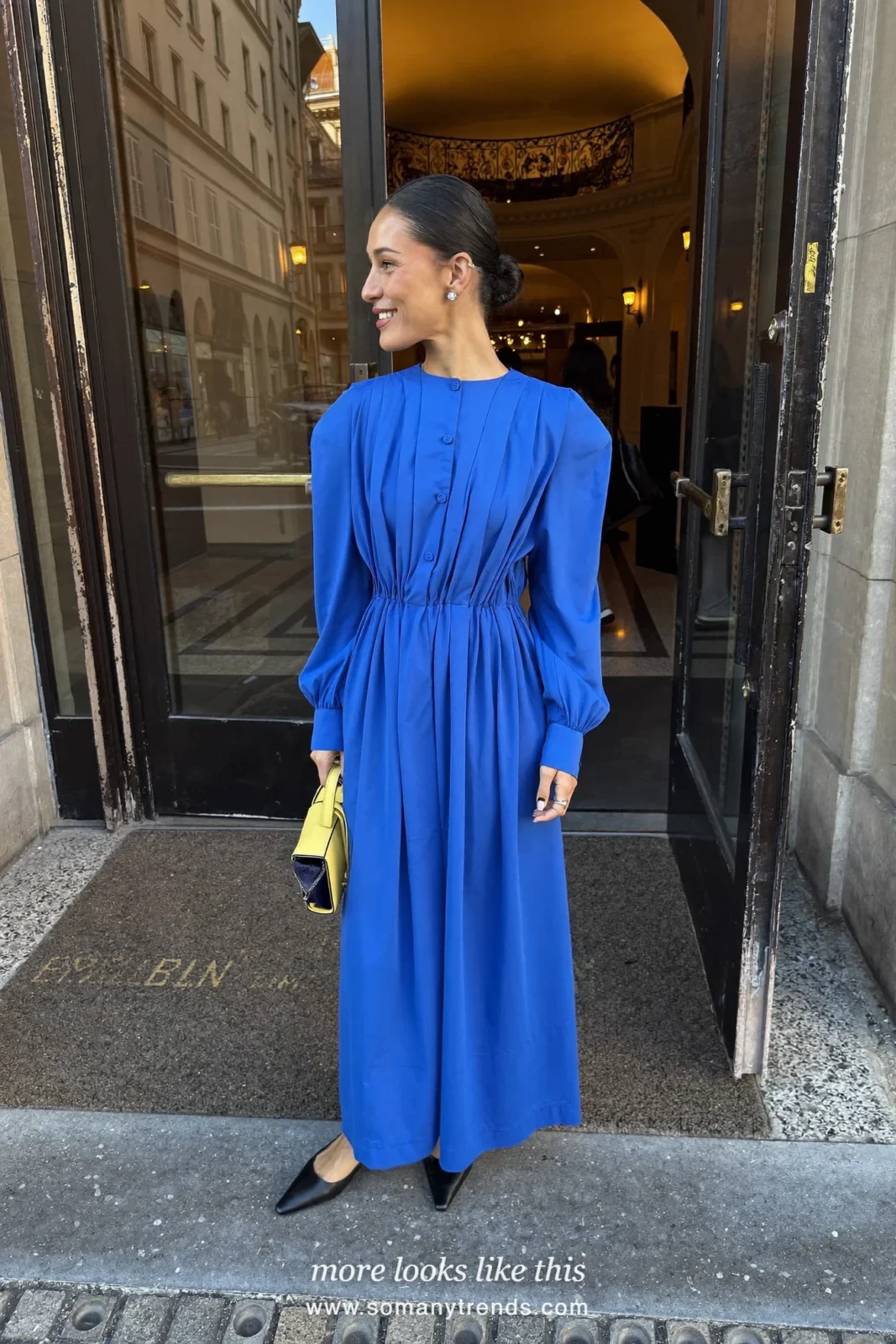 Woman in a cobalt blue long column gown, lemon yellow clutch and black pumps at a formal event entrance, outfit 25