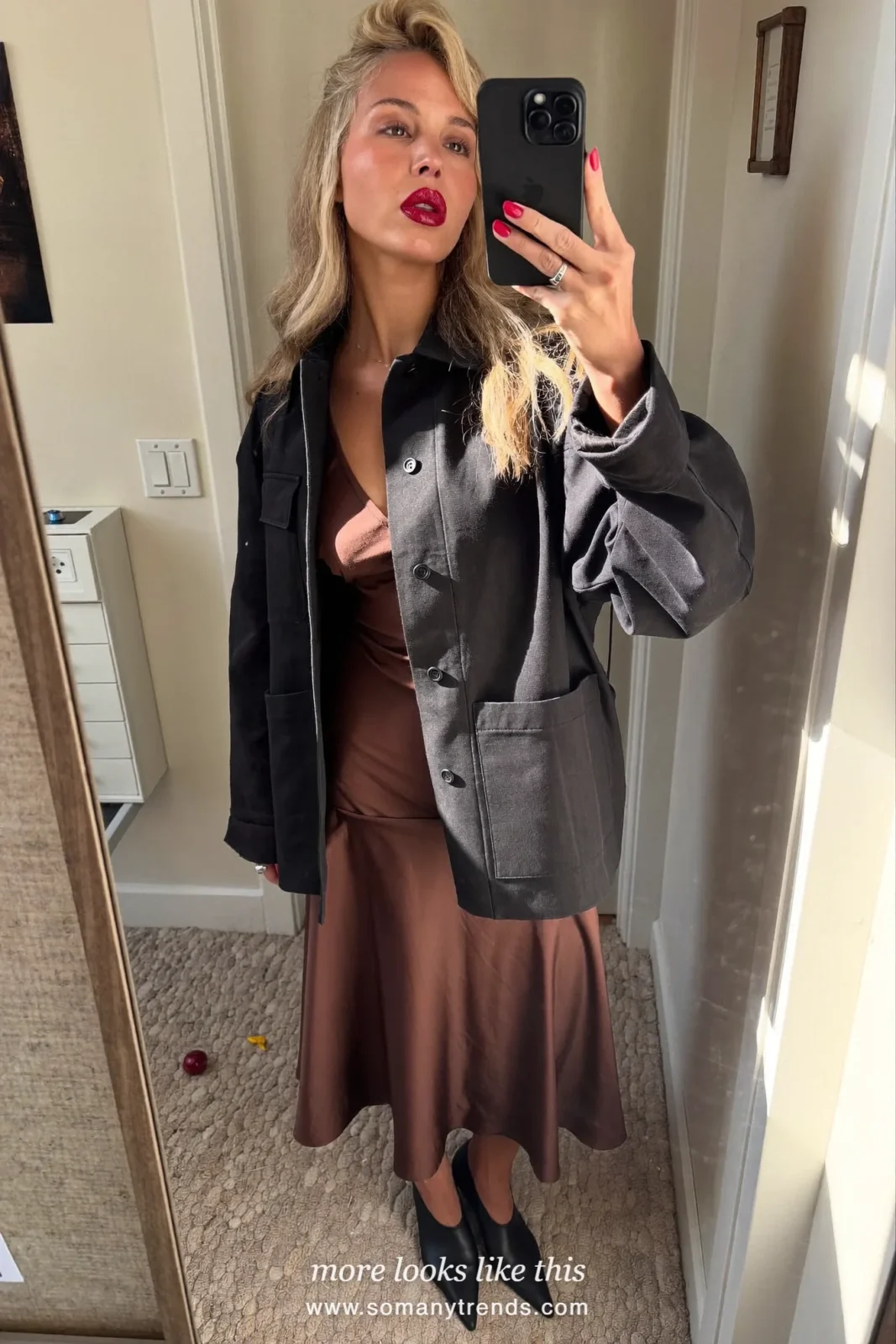 Woman in a chocolate brown satin midi slip dress with a black tailored jacket, black pointed pumps and a black clutch, look 24