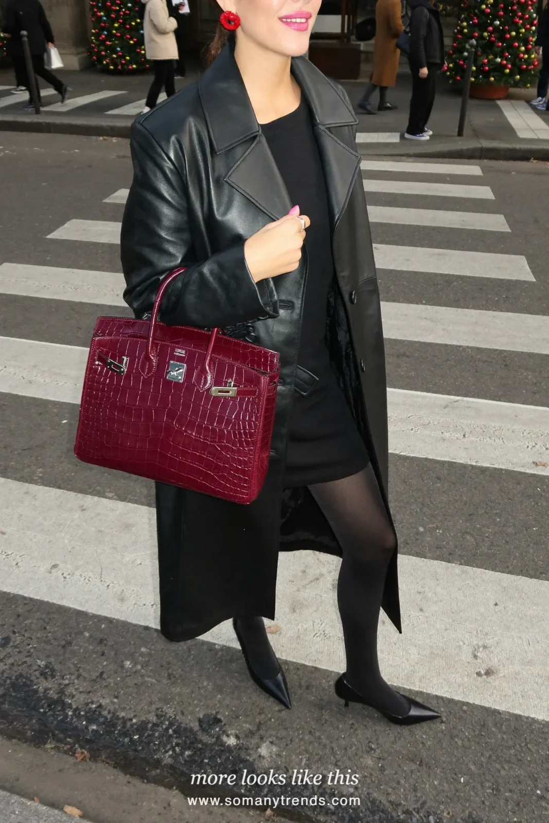Woman in a long black leather trench coat, sheer black tights, black pumps and a burgundy croc top-handle bag, outfit 5