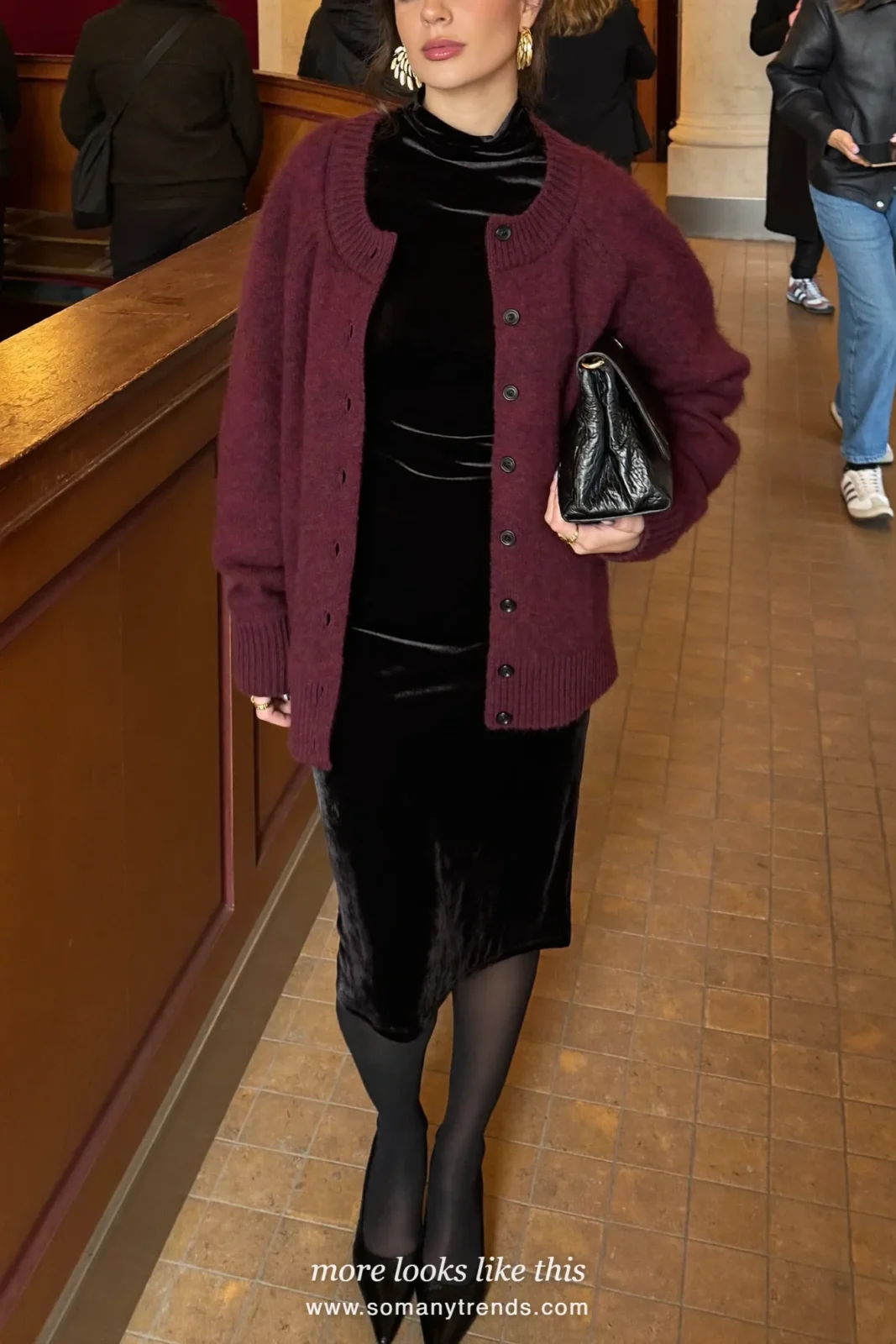 Woman in a black velvet midi dress with a burgundy cardigan, sheer black tights and black pumps, outfit 16