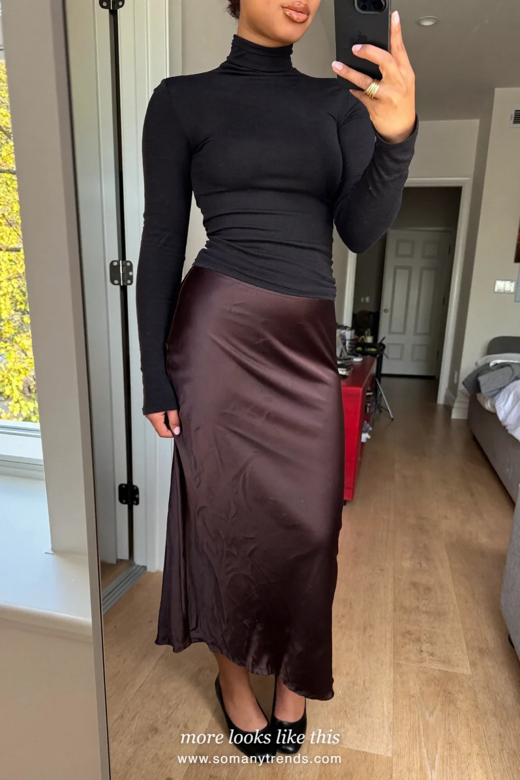 Woman in a black fitted turtleneck, burgundy satin slip midi skirt and black pointed pumps, outfit 21