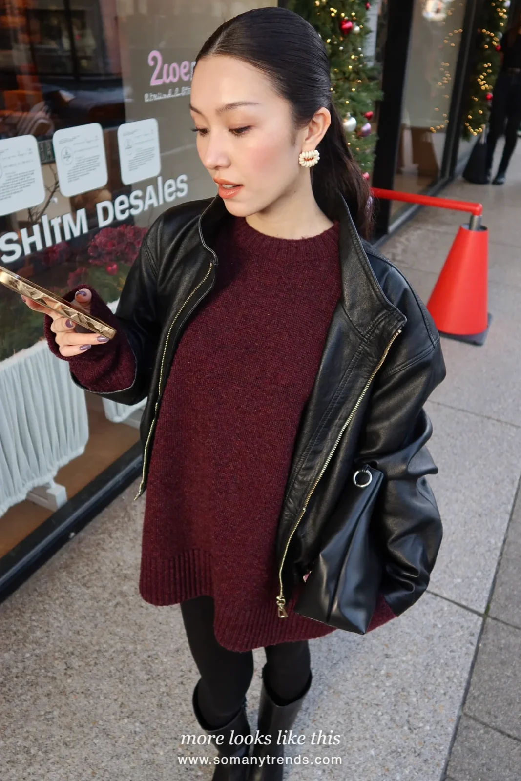 Woman in a black leather jacket, loose burgundy knit mini dress, black opaque tights and black boots, outfit 22