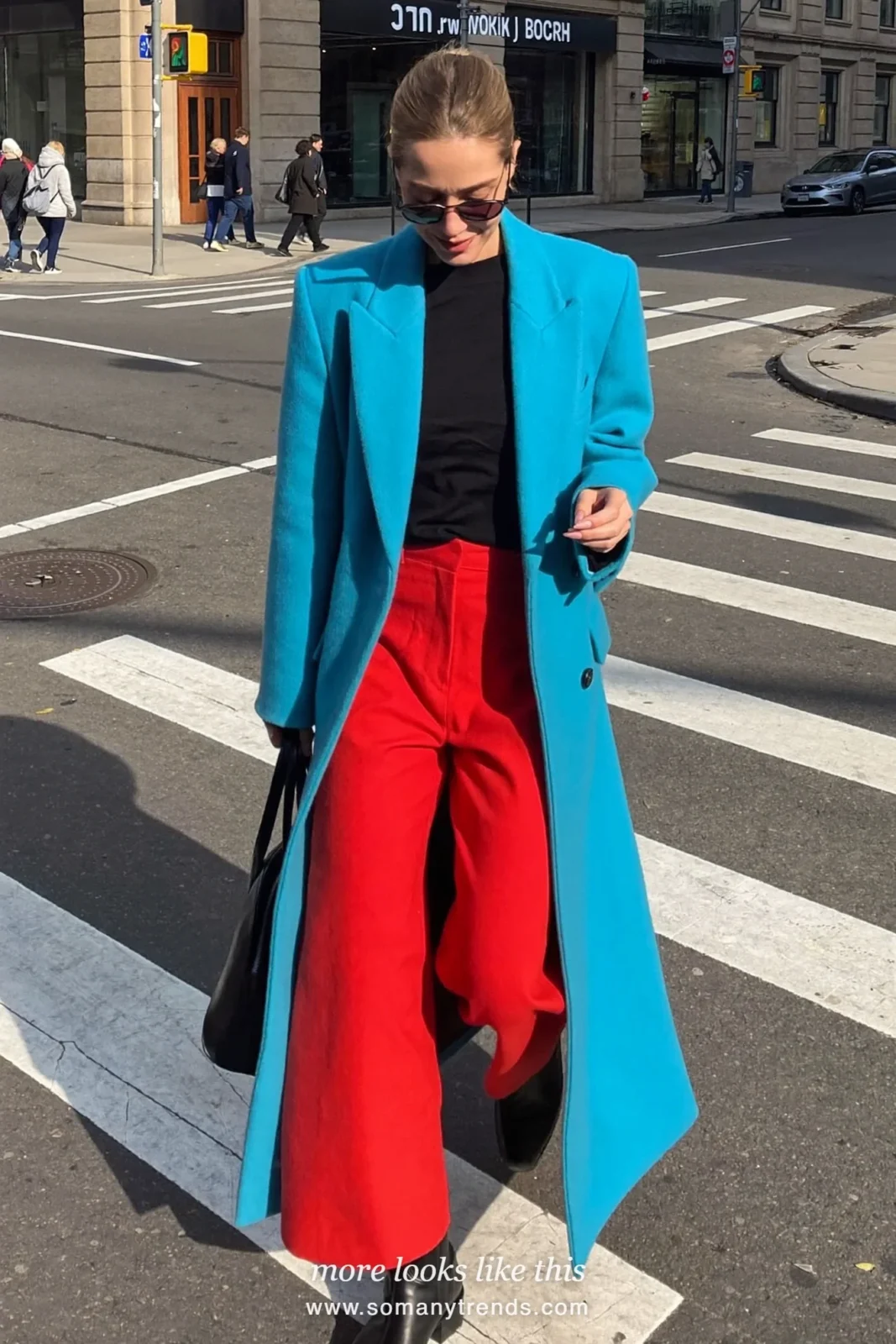 Woman in a long oversized aqua coat, black knit, coral red straight pants and black boots, outfit 4