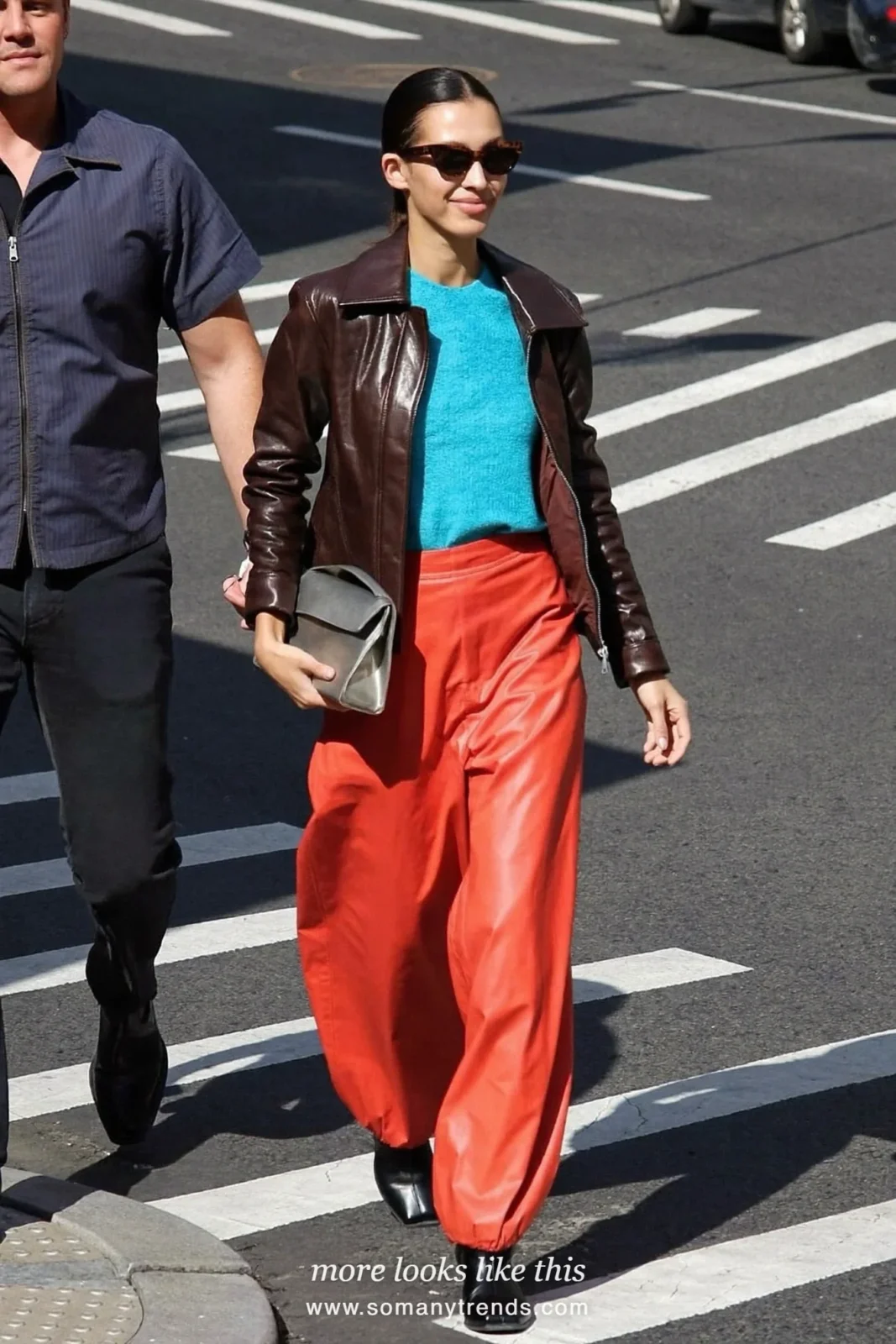 Woman in coral red faux leather balloon pants, dark brown zip jacket, aqua top and black boots, outfit 10