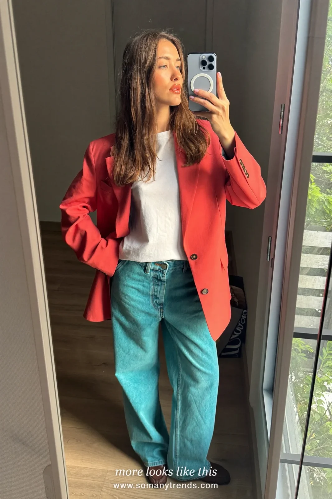 Woman in a coral red blazer, white tee, wide aqua jeans and brown loafers, outfit 15